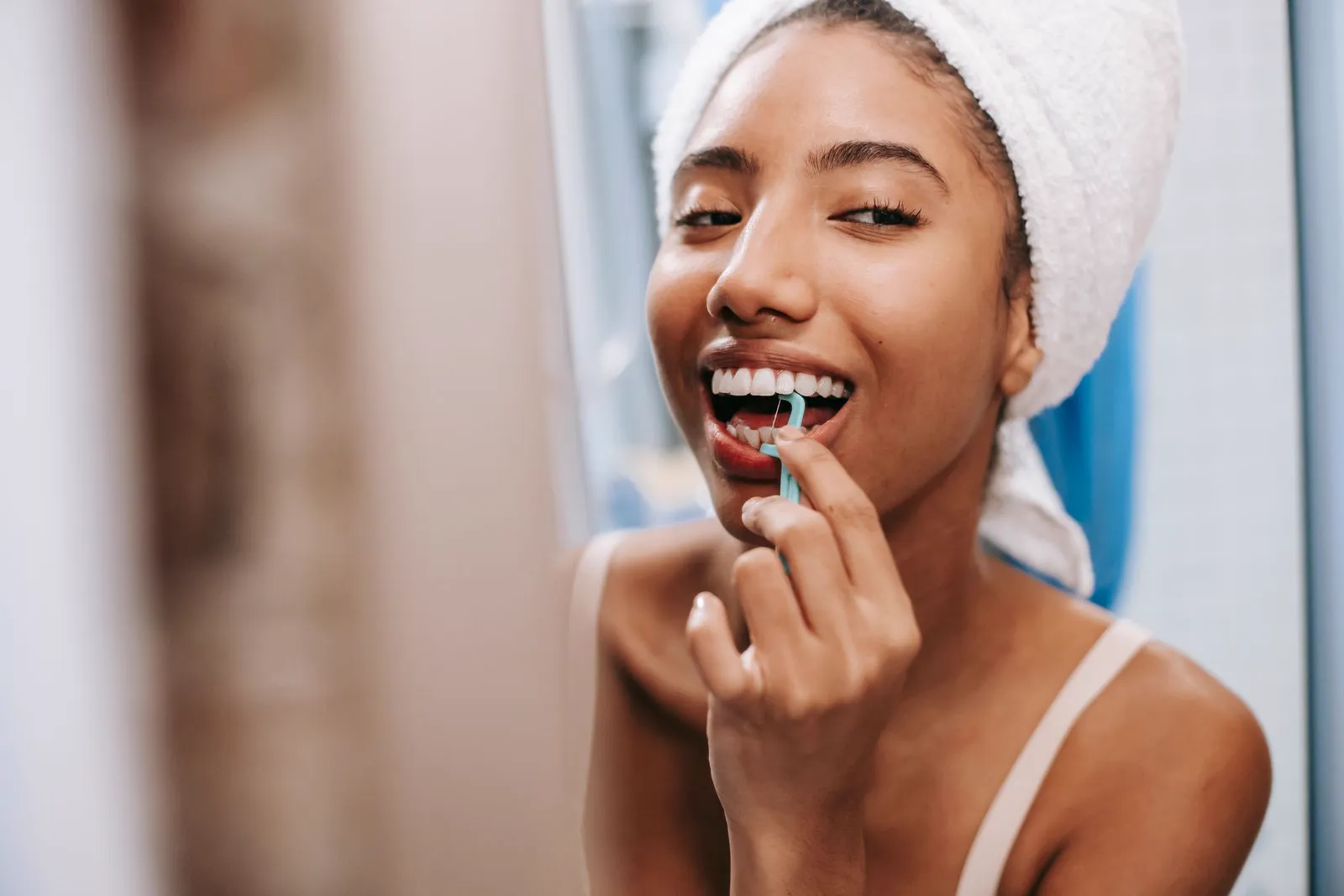 Femme prenant soin de son sourire avec du fil dentaire
